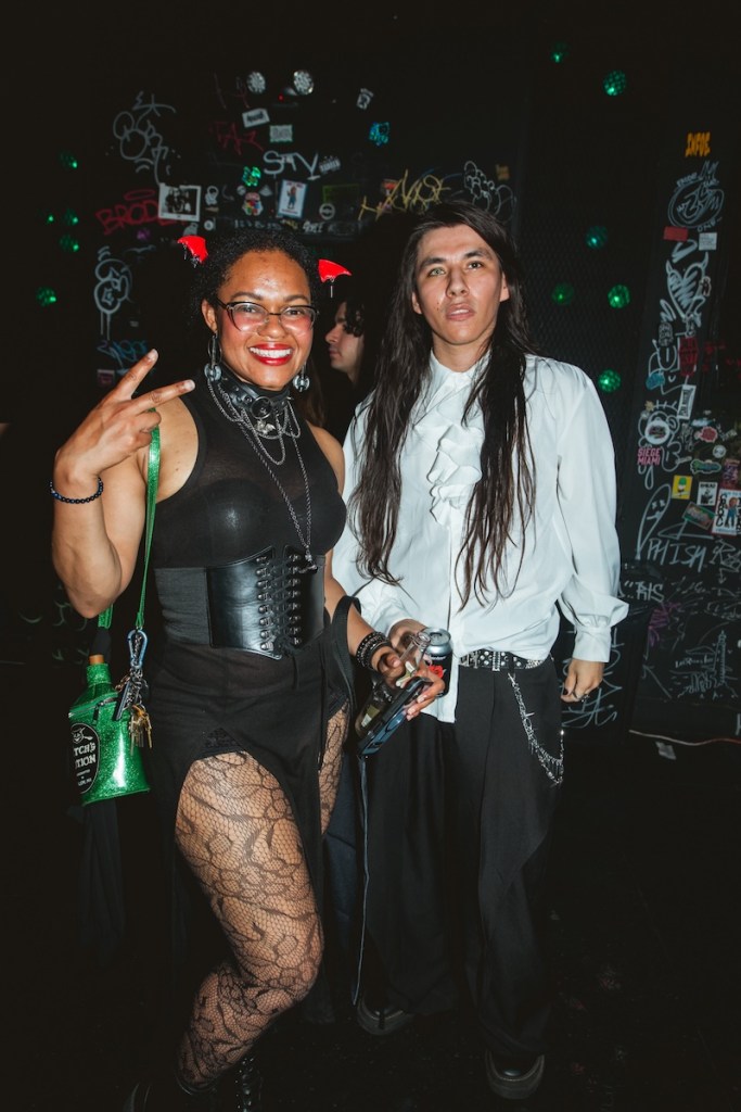 Photo of a woman wearing a black dress and a corset and a man with long hair wearing a white Victorian style shirt