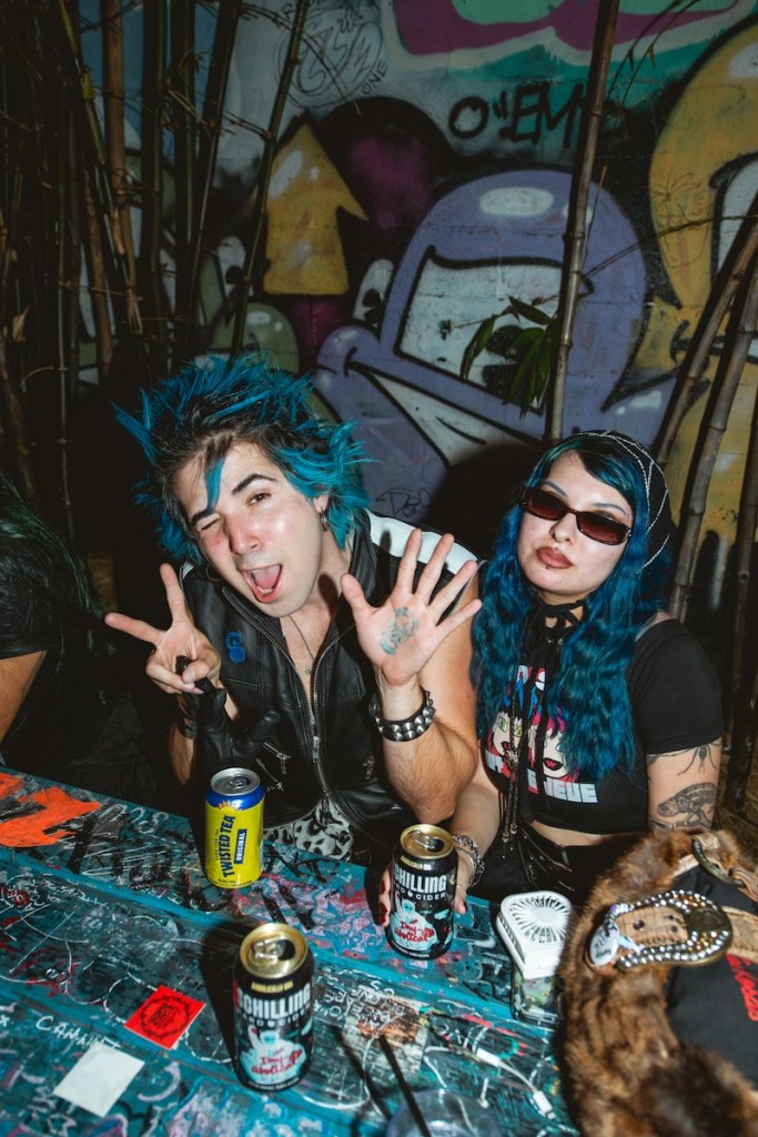 Photo of two people with blue hair drinking a beer at a Miami bar