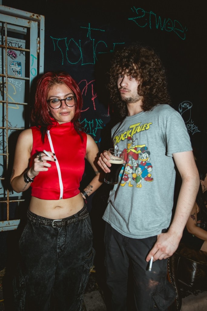 Photo of two people at a Miami bar, one holding a cigarette and another one drinking a beer