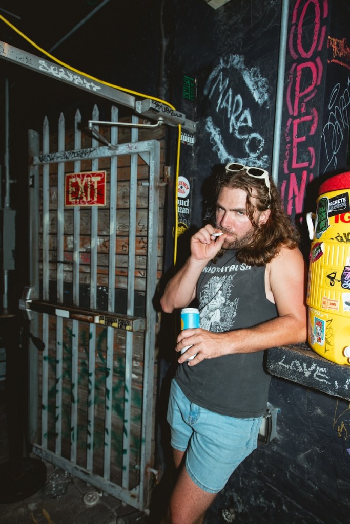 Photo of a man with long hair smoking a cigarette at a Miami bar