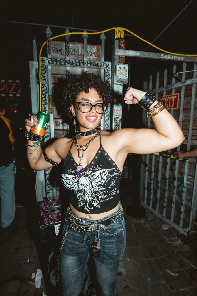 Photo of a woman with short curly hair flexing her arms and showing her muscles