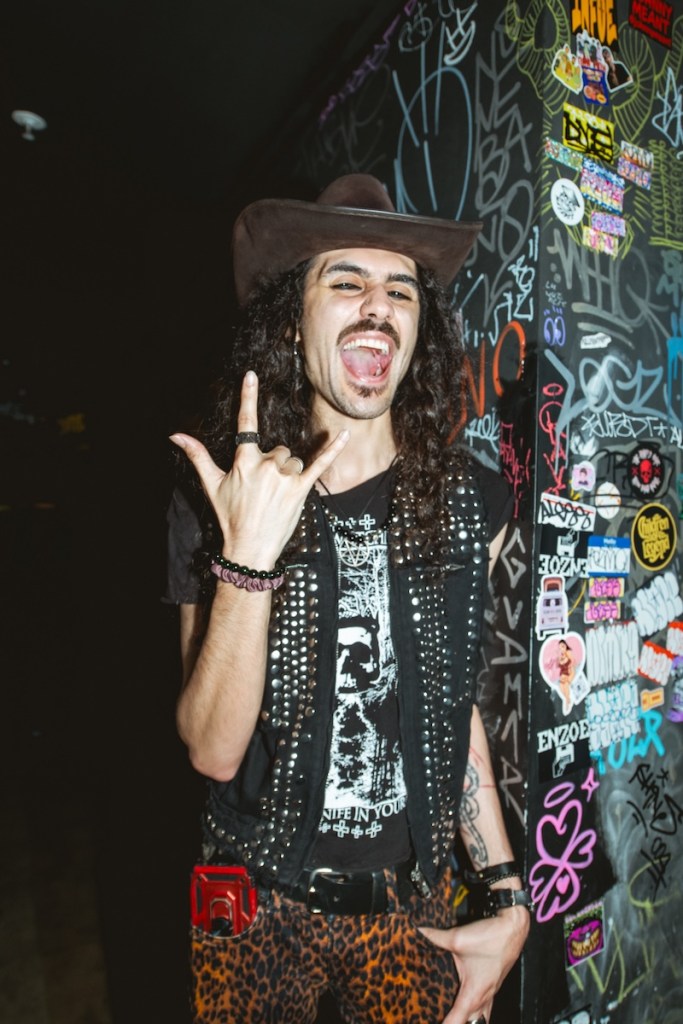Photo of a man with long hair and wearing a leather vest