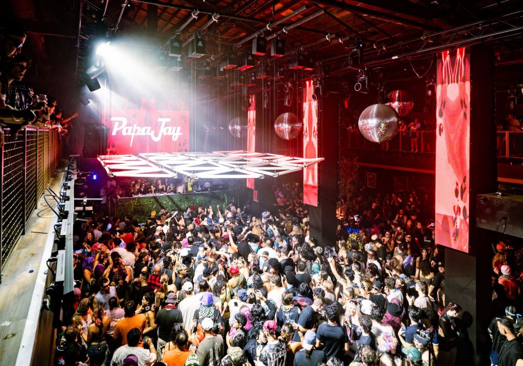 Photo of a nightclub in Miami with a big crowd and red LED screens.