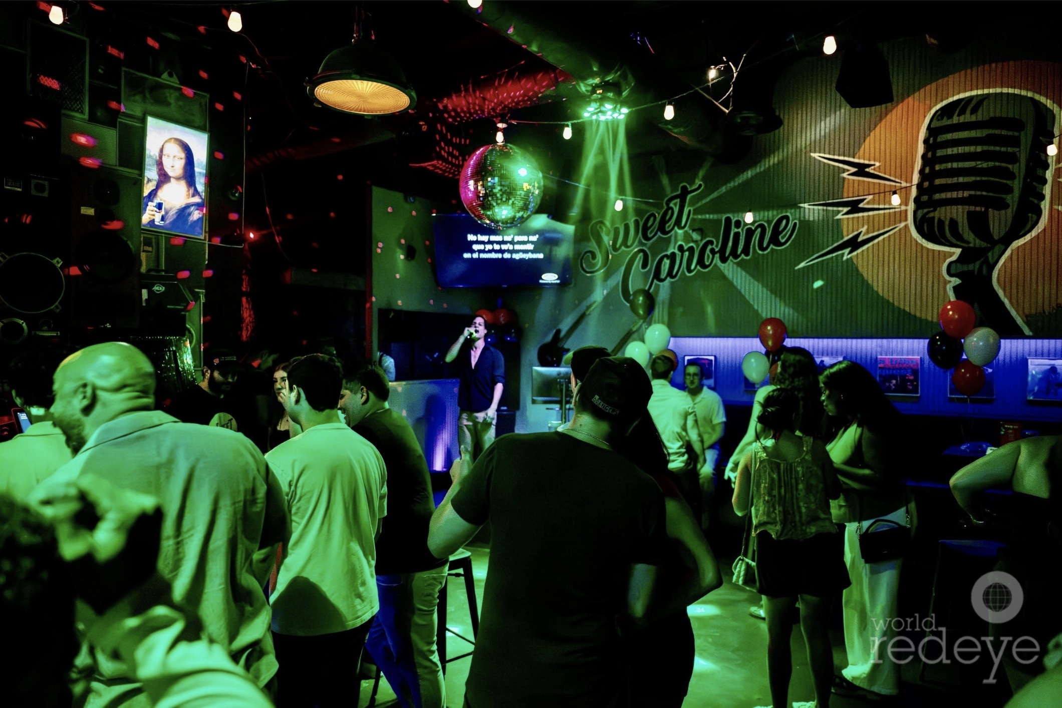 photo of partiers inside a club with green lighting