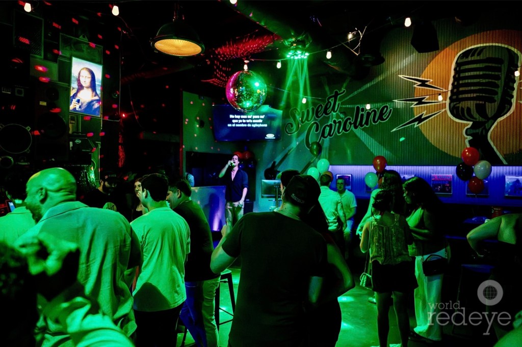 photo of partiers inside a club with green lighting