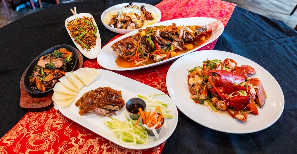 an assortment of Chinese dishes on a black and red table