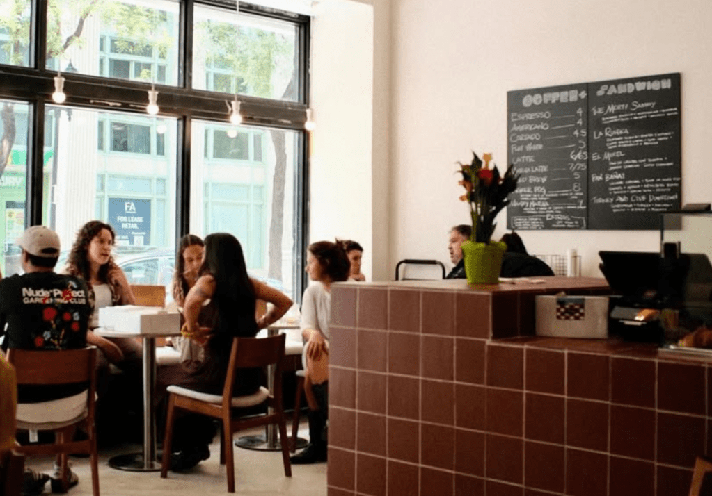the dining area of a bakery with seating and a tile counter