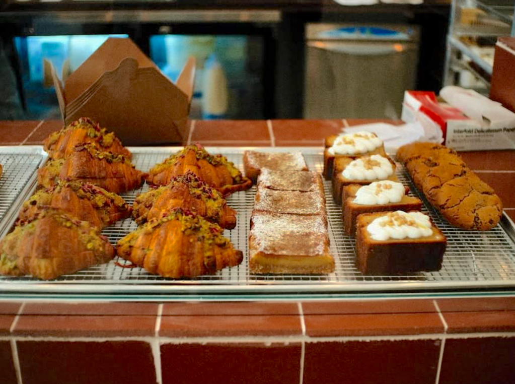 an assortment of pastries behind a display case