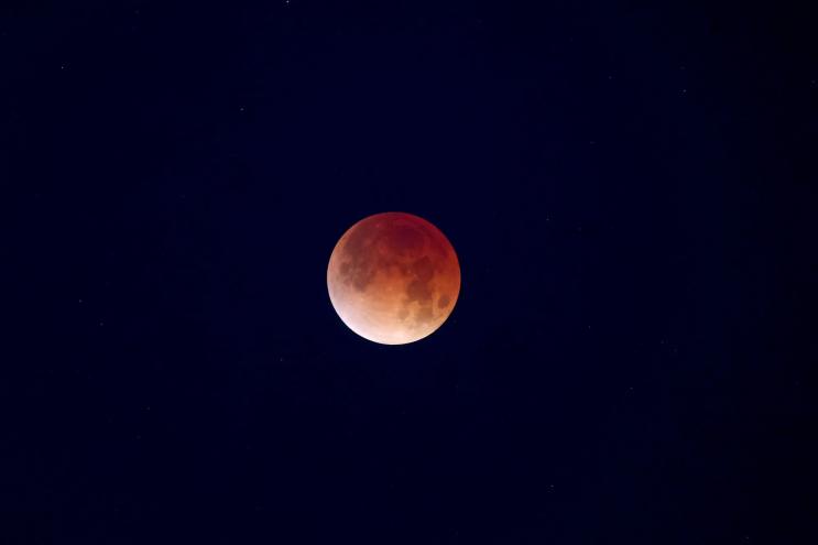 the moon shaded red thanks to a partial lunar eclipse
