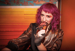 Picture of a woman with purple hair looking at the camera.