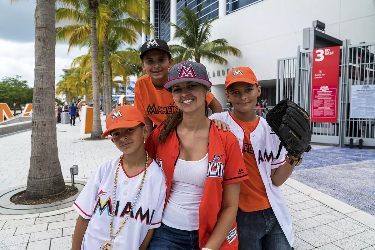 photo of a woman and three boys dressed in Miami Marlins gear in front of the ballpark