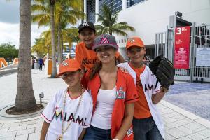 photo of a woman and three boys dressed in Miami Marlins gear in front of the ballpark
