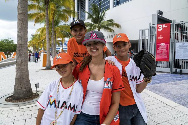 photo of a woman and three boys dressed in Miami Marlins gear in front of the ballpark