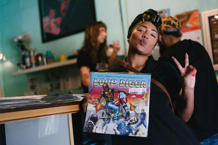 Photo of a young happy woman holding a record in Miami record store.