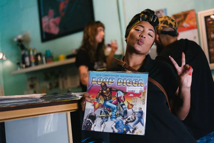 Photo of a young happy woman holding a record in Miami record store.