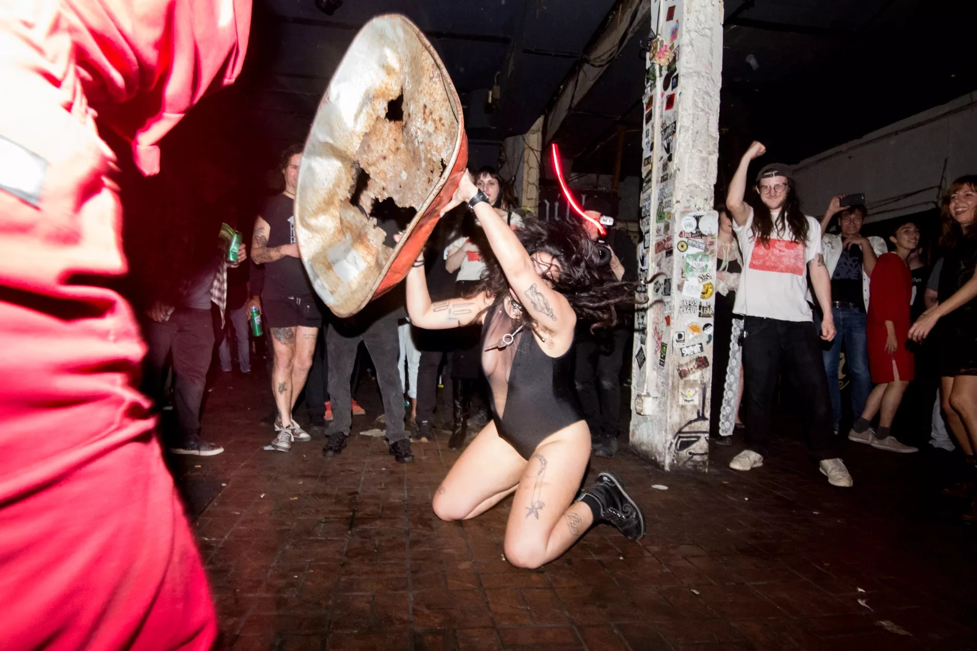 Photo of a woman on a stage pn her knees holding a metal structure