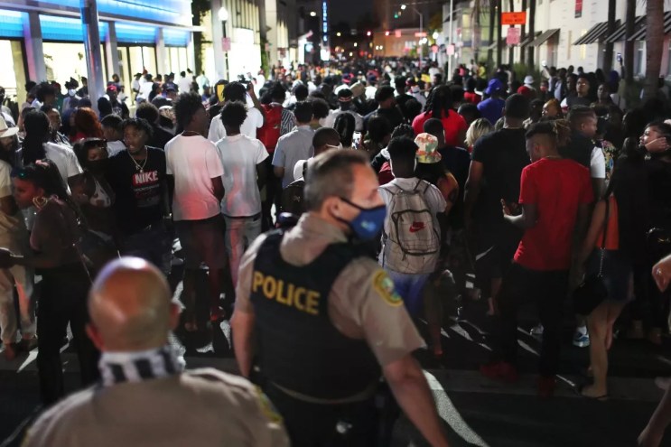 People leave the area as an 8pm curfew goes into effect on March 21, 2021, in Miami Beach, Florida. College students arrived in the South Florida area for the annual spring break ritual, prompting city officials to impose an 8pm to 6am curfew as the coronavirus pandemic continued. Miami Beach police reported hundreds of arrests and stepped up deployment to control the growing crowds.