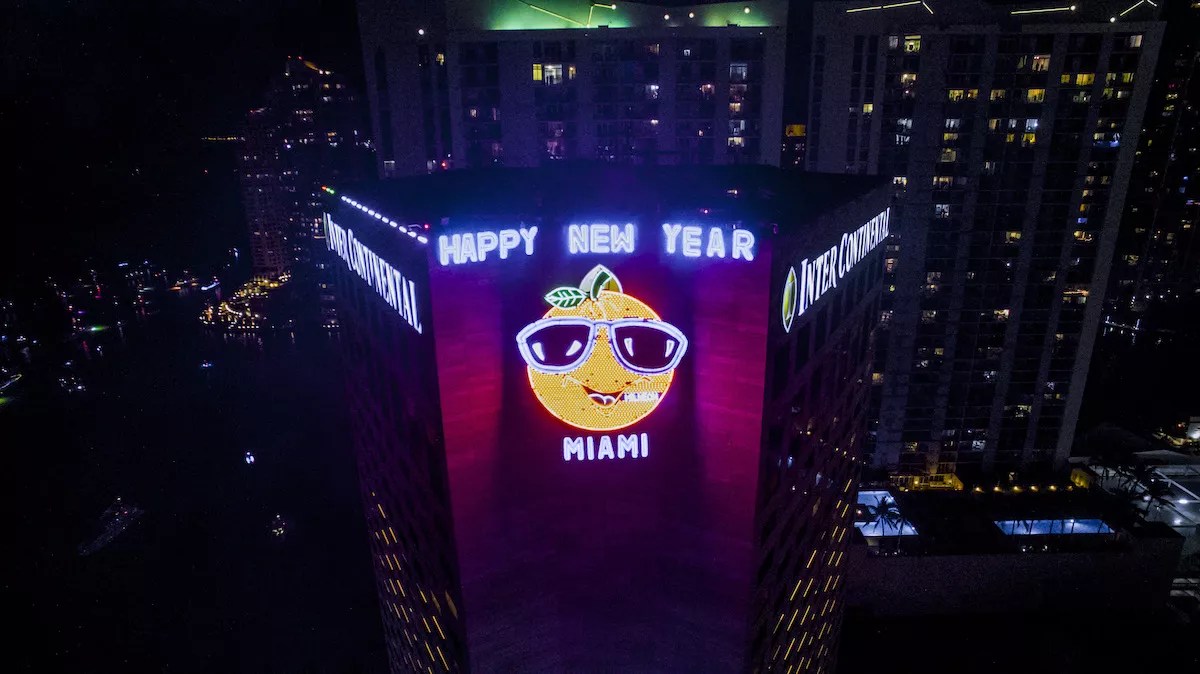 Neon orange caricature on the side of the InterContinental Hotel in Miami