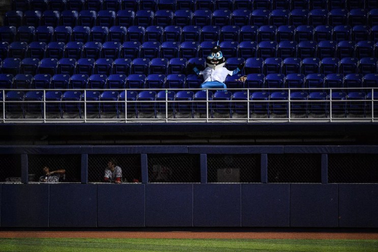 2020 photo of Miami Marlins mascot Billy the Marlin at a late-season game at Marlins Park, sprawled in a dark blue seat in an otherwise-empty section overlooking the left field bullpen