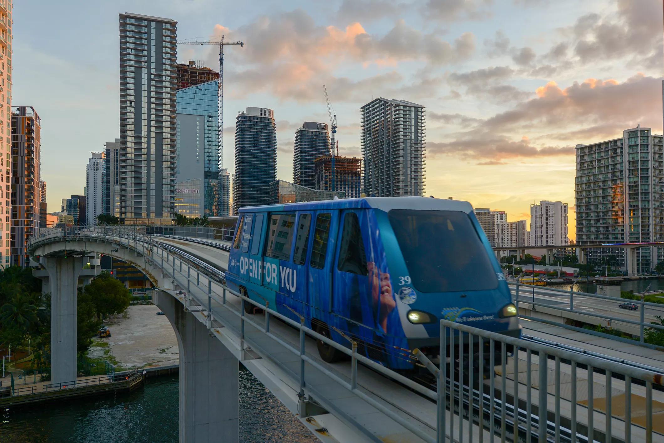 A blue Metromover train rides along the tracks in Miami