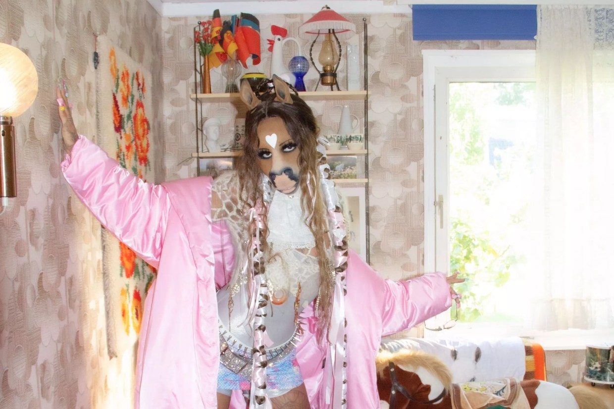 HorsegiirL, a DJ who wears a horse mask, poses in a room