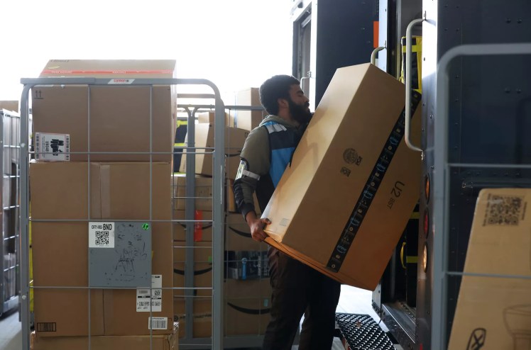 Amazon worker loading packages into delivery van