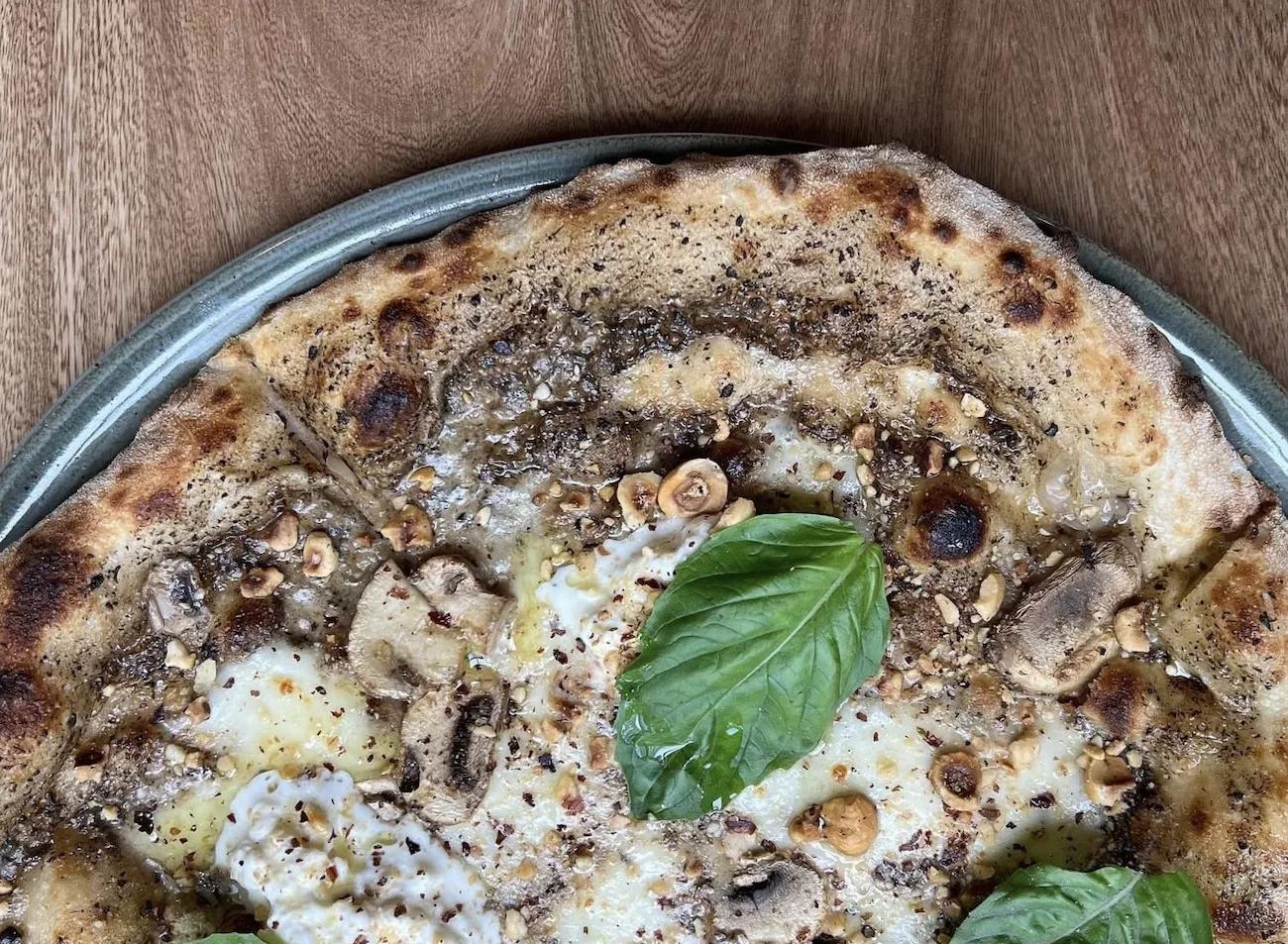 A close-up of a pizza with basil