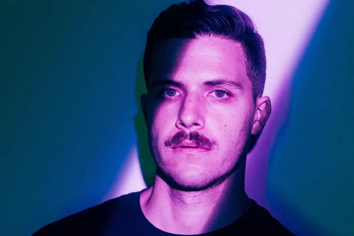 DJ and producer Enamour illuminated with a purple light