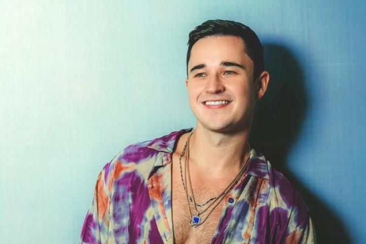 DJ and producer John Summit standing against a blue background