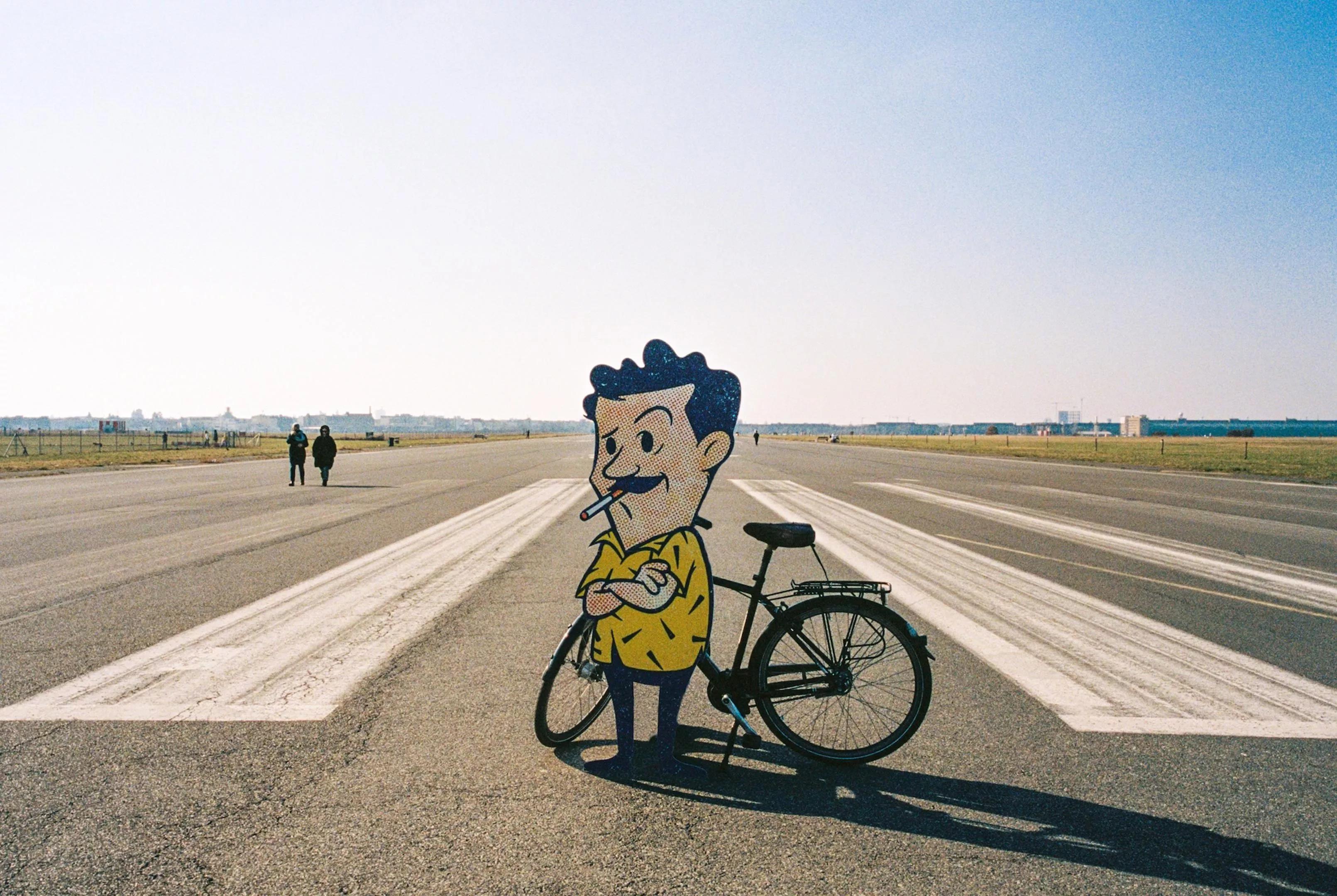 Gene On Earth's animated character in front of a bike while standing on a runway.
