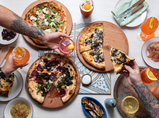 Pizzas and cocktails on a white table