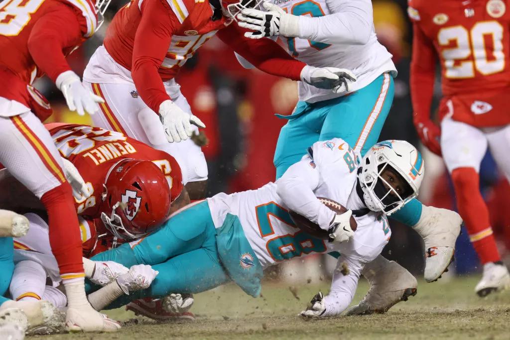 Miami Dolphins running back De'Von Achane is pulled to the frozen ground in an NFL playoff game against the Kansas City Chiefs
