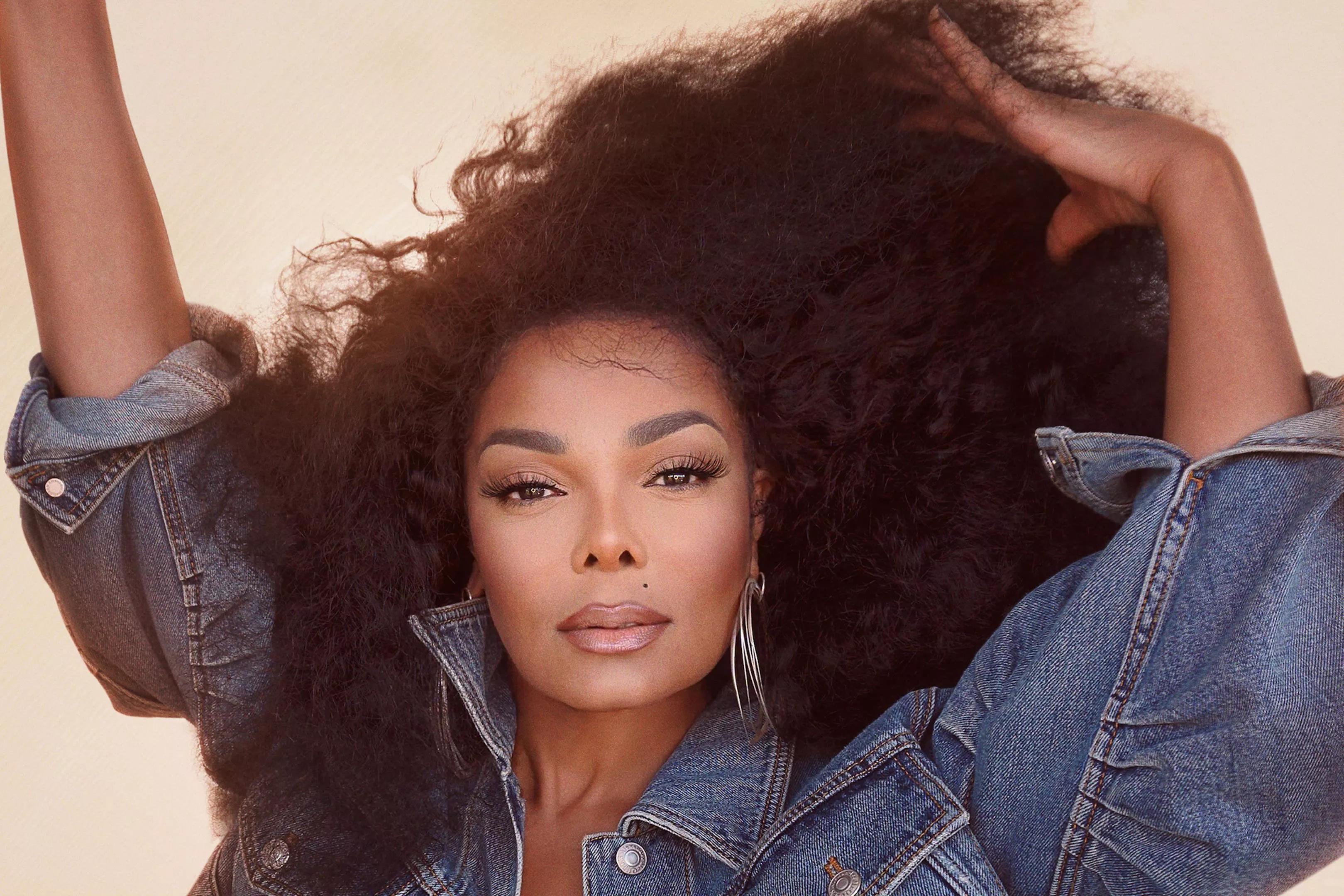 Janet Jackson starring at the camera while brushing her hair with her fingers