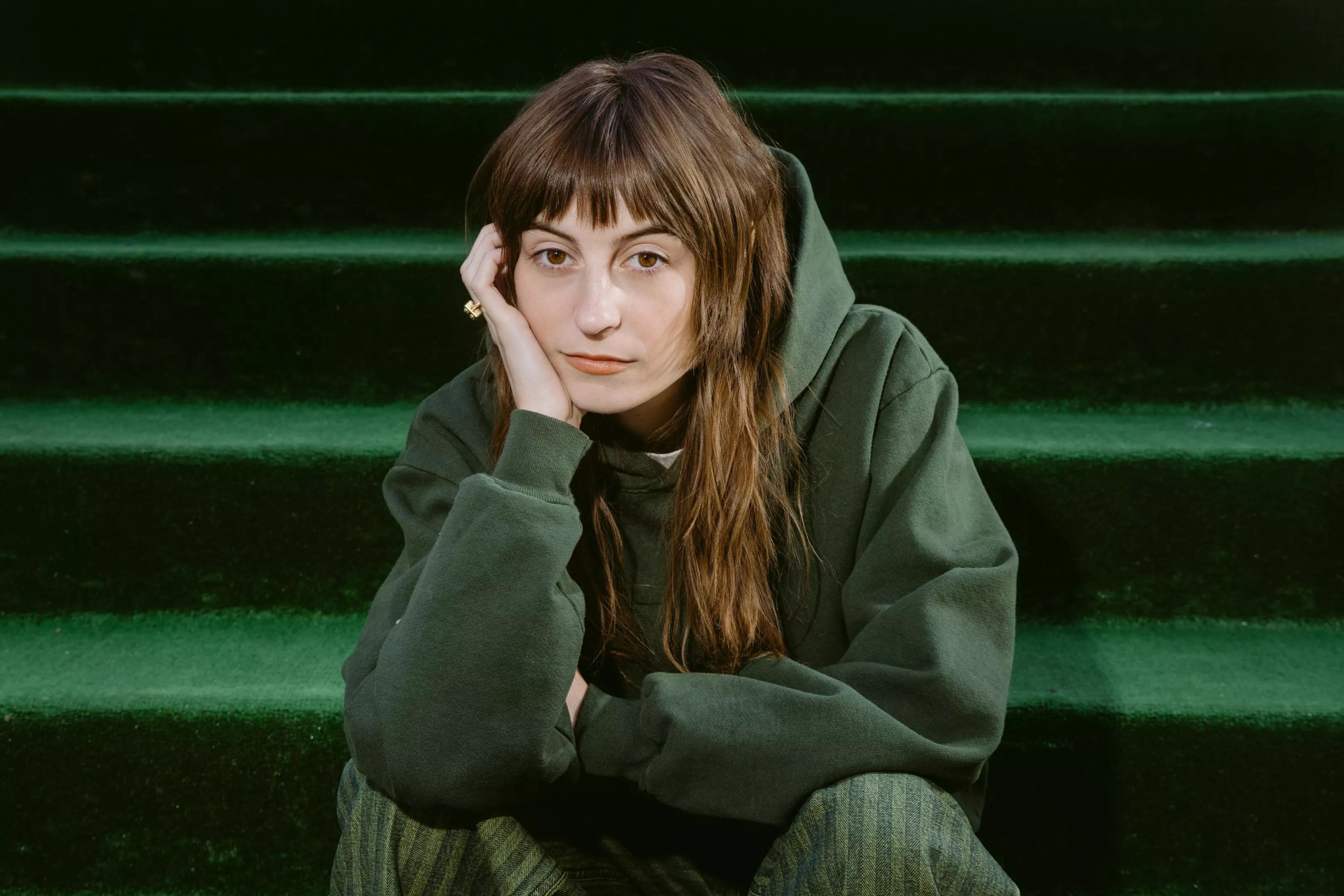 faye webster in a green sweater