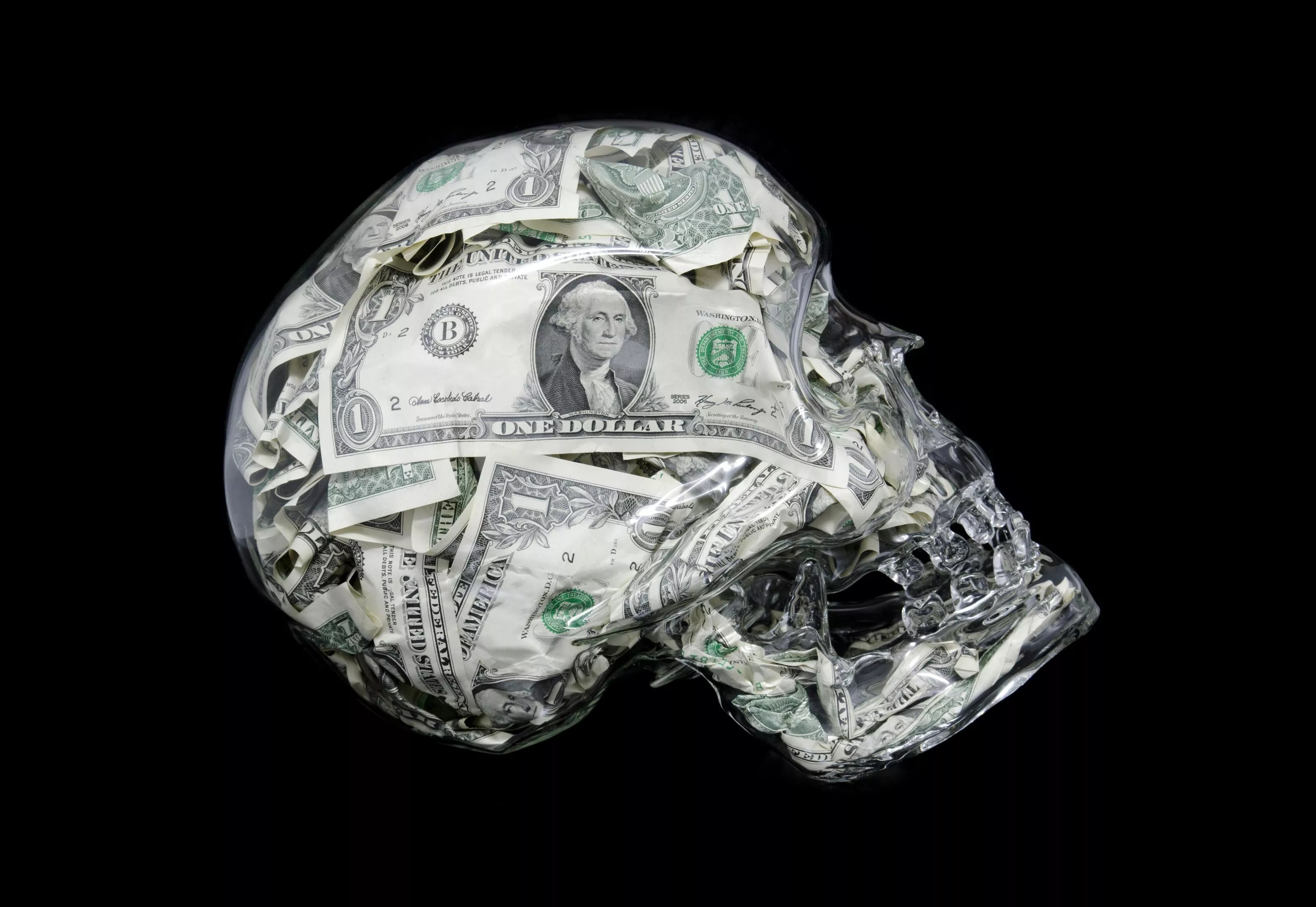A glass skull filled with U.S. dollars