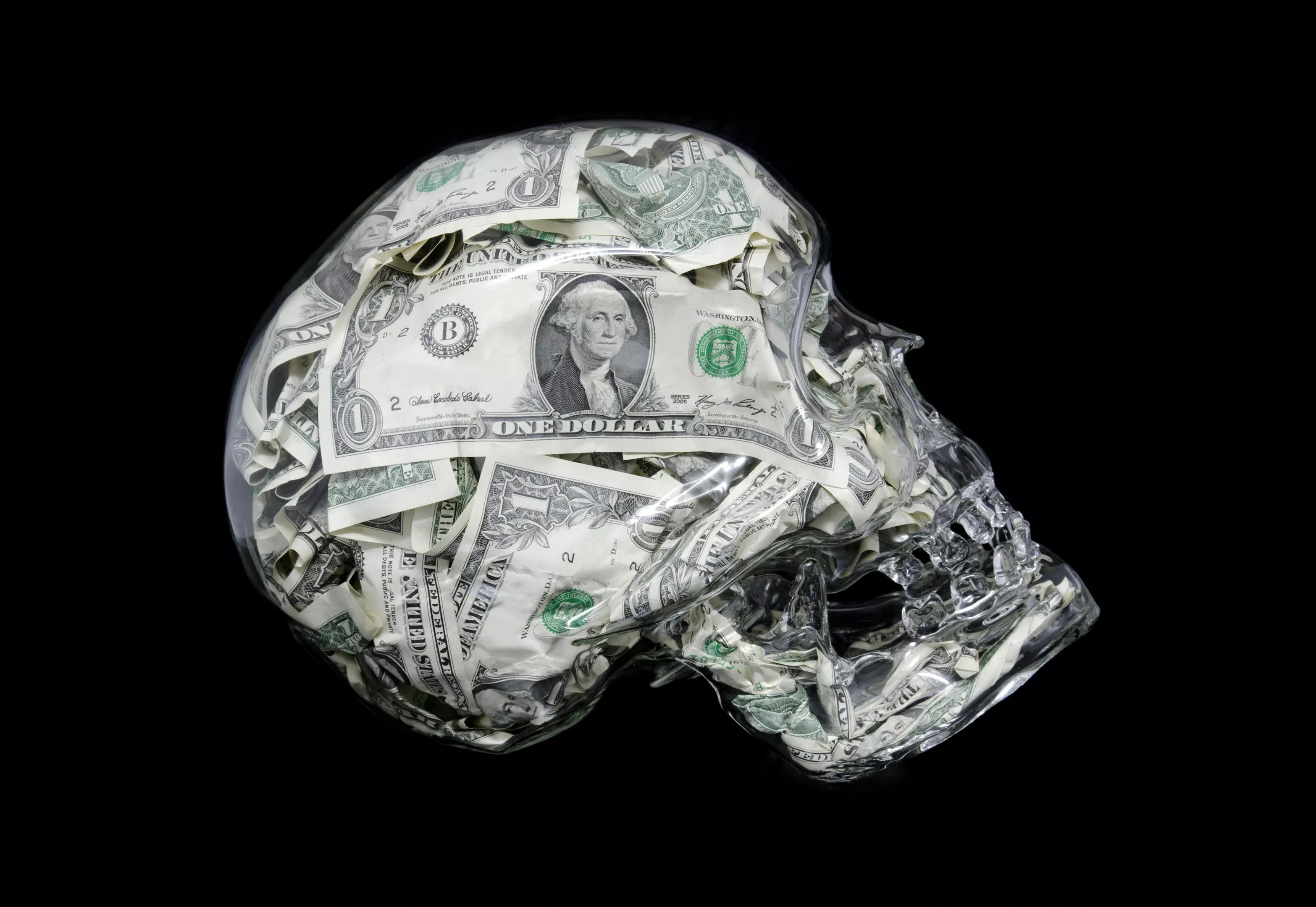 A glass skull filled with U.S. dollars