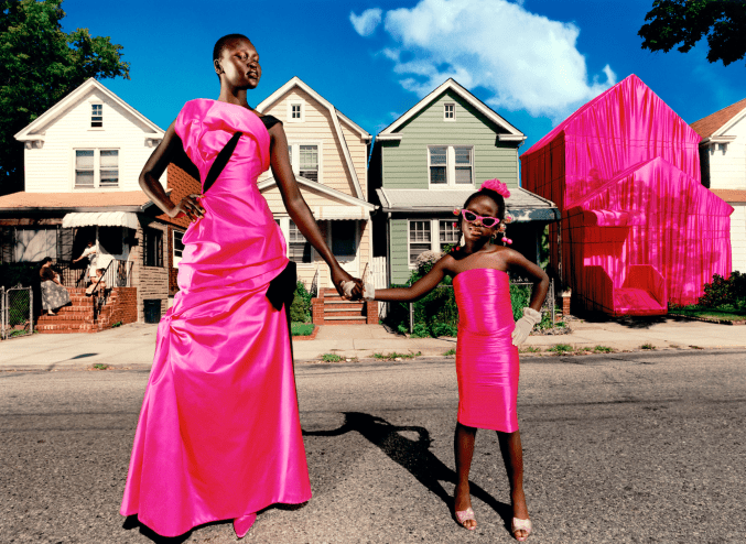 Black woman and child posing on the street in hot-pink dresses