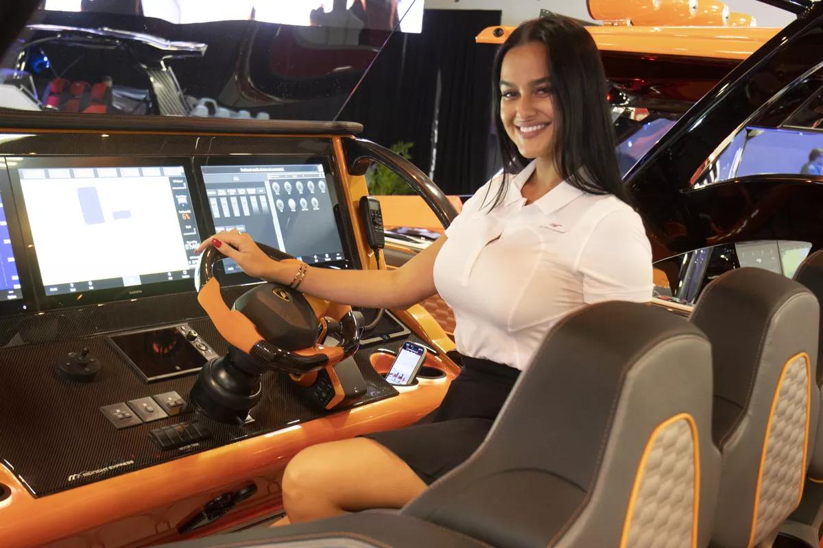 Woman poses at the controls of a boat
