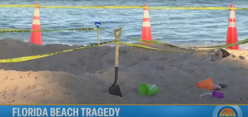 Beach toys, a shovel, and a cone sit on the beach at the site of a fatal sand collapse