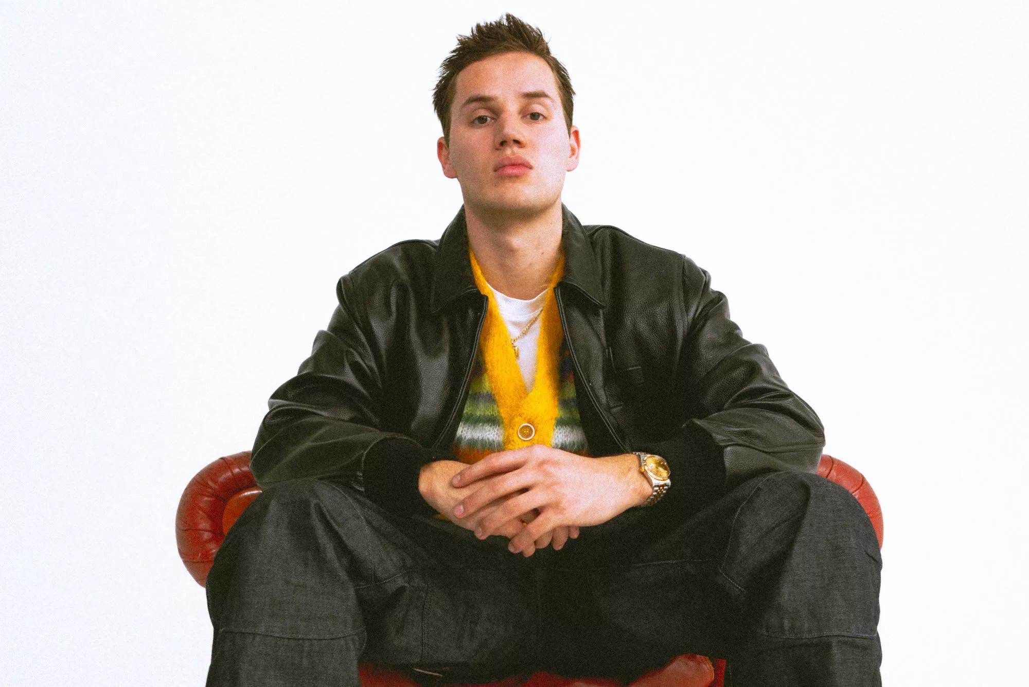 Mau P sitting on a red leather chair