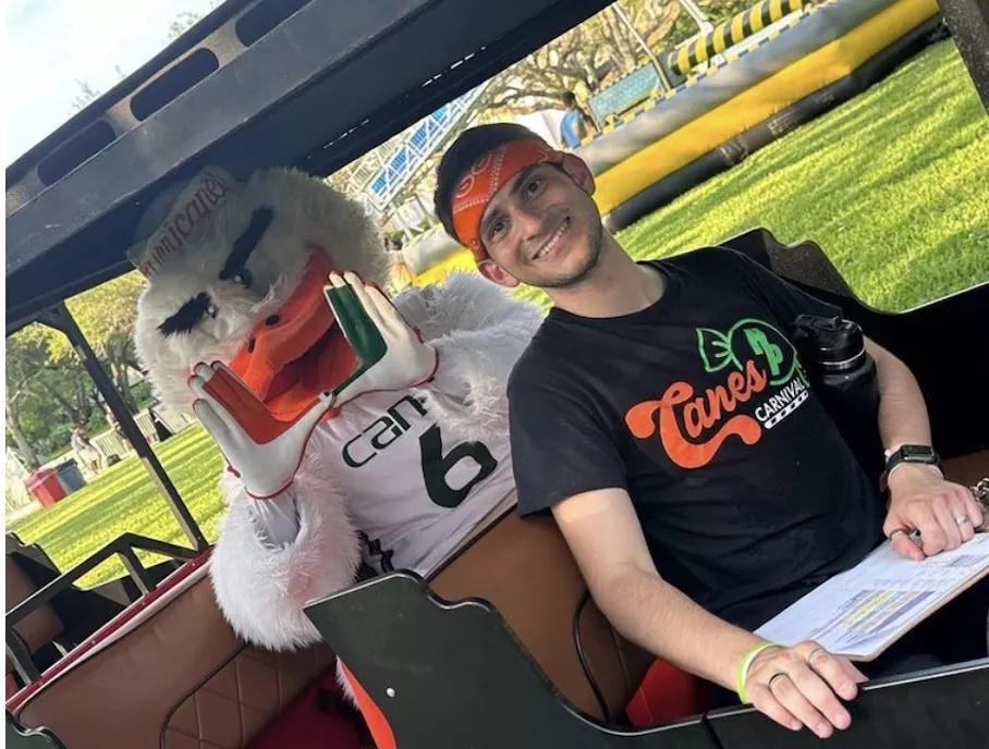 A photo of UM student Danny Bishop riding with a Hurricanes mascot