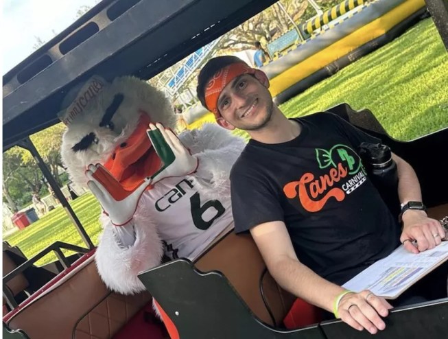 A photo of UM student Danny Bishop riding with a Hurricanes mascot