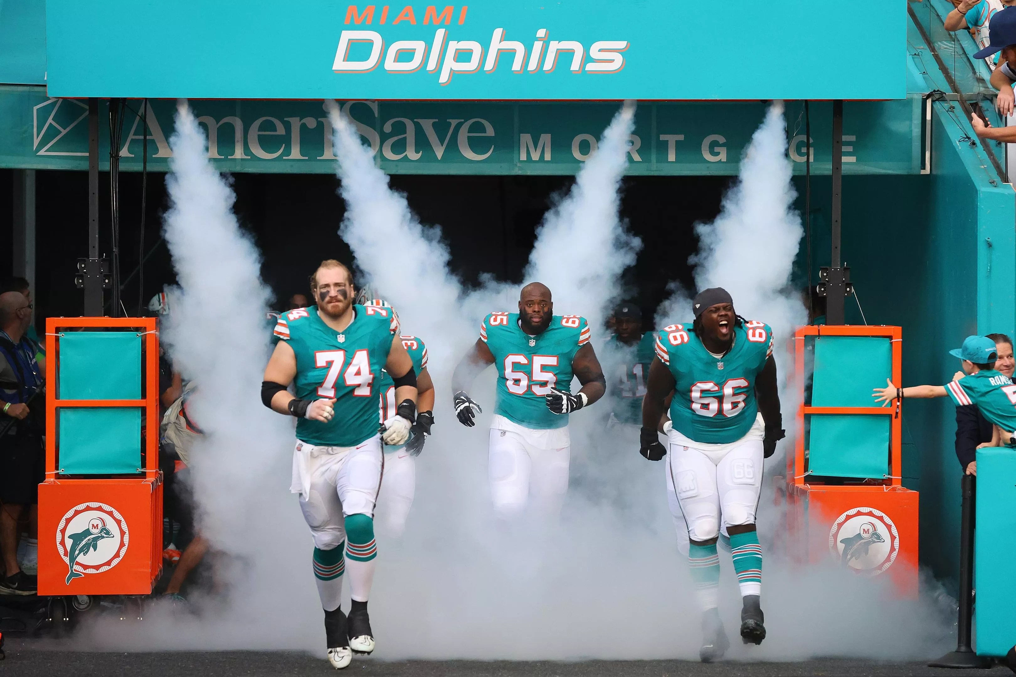 The Miami Dolphins trot onto their home field in Miami Gardens before a game