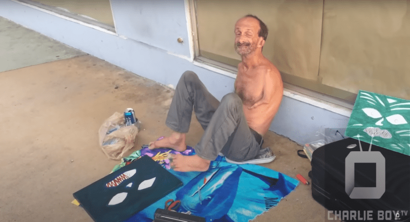 Jonathan Crenshaw, a well-known homeless South Beach street artist with no arms, paints a canvas using his feet.