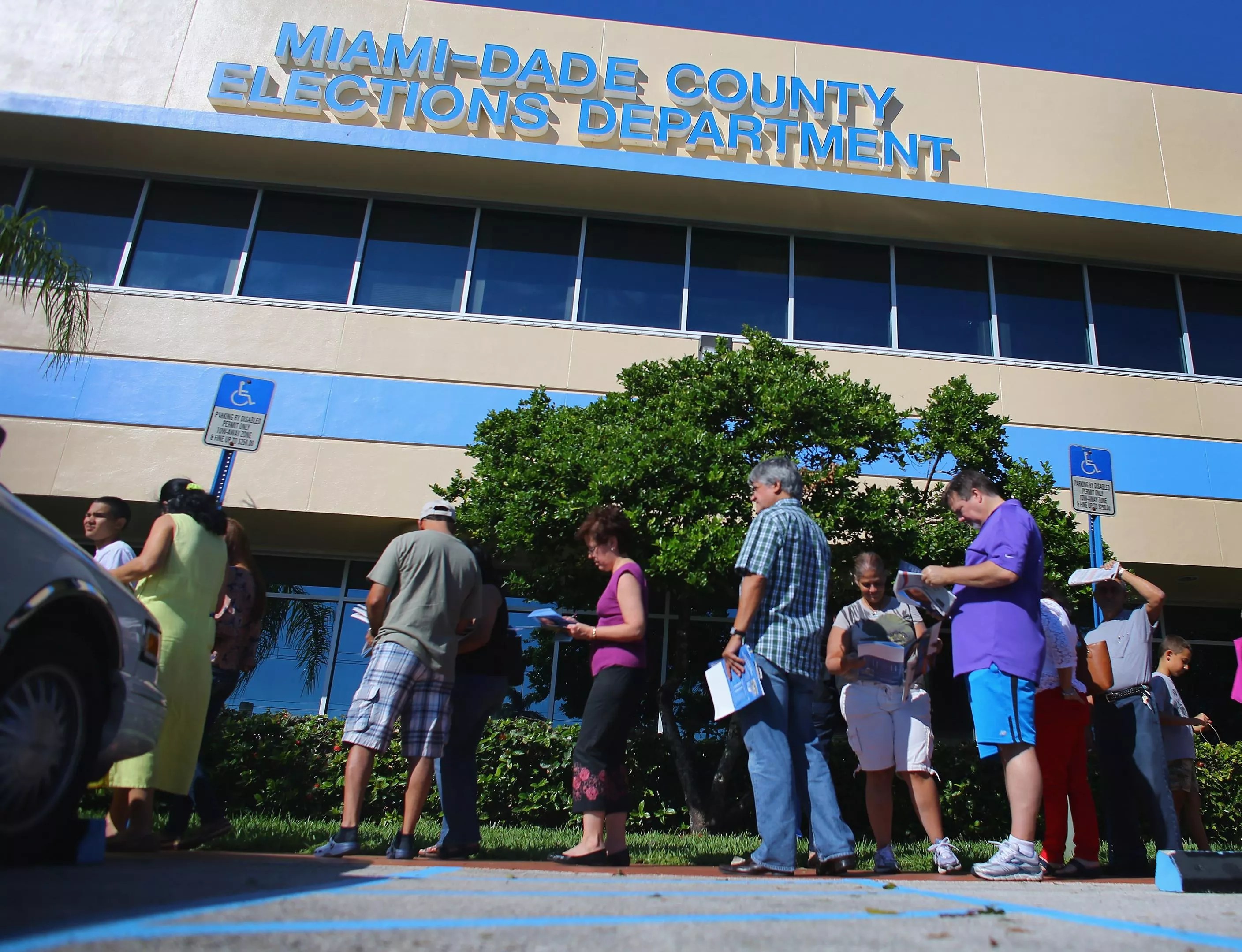 A small group of residents stand outside a county elections building