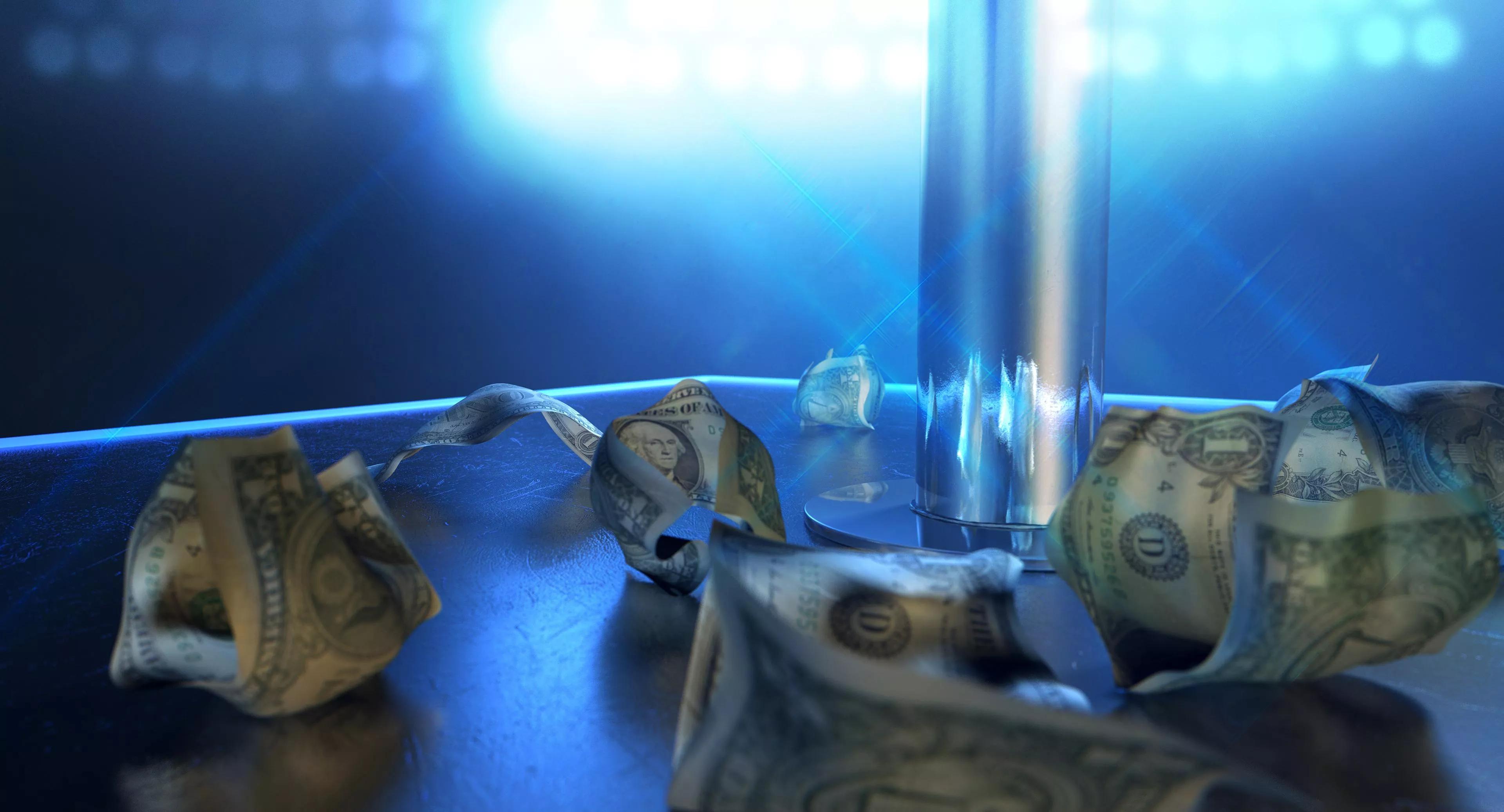An isolated stripper pole on a stage lit by a single spotlight surrounded by crumpled up one dollar bills