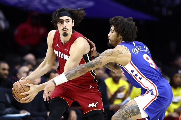 Jaime Jaquez of the Miami Heat holds the basketball away from a Philadelphia 76ers reaching out for a steal