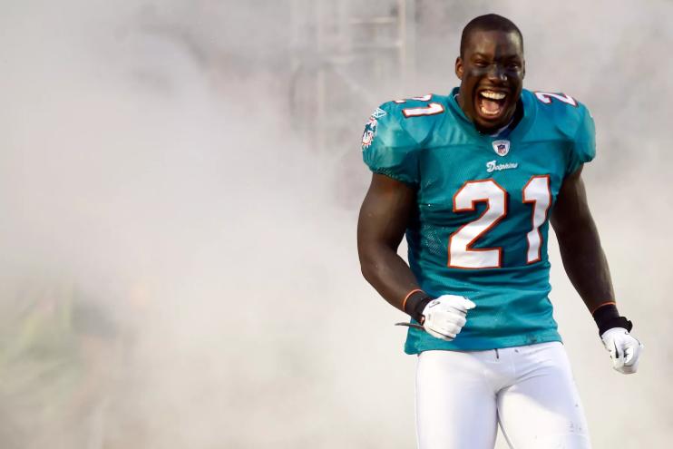 color photo of Miami Dolphins cornerback Vontae Davis grinning from ear to ear as he trots onto the field surrounded by "smoke" during player introductions on September 12, 2011