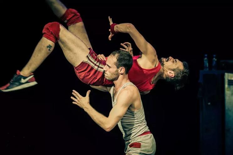 A dancer lifting another dance by the waist