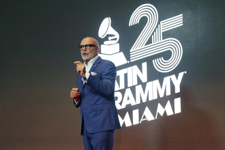 Manuel Abud in a blue suit speaking on stage.